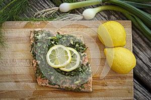 Salmon with lemon and dill on cutting board