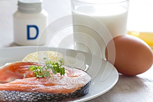 Salmon, milk, eggs and cheese, in background vitamin D. Natural sources of vitamin D and supplement