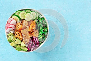 Salmon poke bowl with avocado, cucumbers, wakame, radish, and purple cabbage