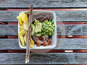 Salmon poke bowl with rice red quinoa edamame mango chopsticks