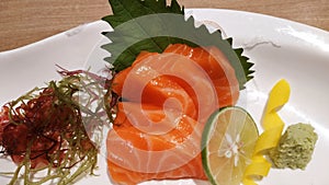 Salmon raw fillet fish sliced japanese sashimi alacarte foods menu on white dish