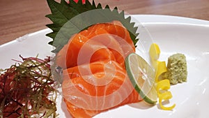 Salmon raw fillet fish sliced japanese sashimi alacarte foods menu on white plate