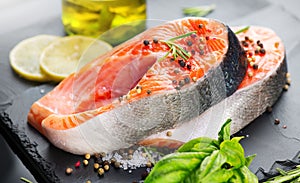 Salmon. Raw Trout Red Fish Steak served with Herbs and Lemon and olive oil on slate. Cooking Salmon, sea food