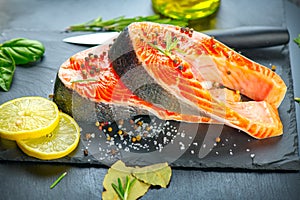 Salmon. Raw Trout Red Fish Steak served with Herbs and Lemon and olive oil on slate. Cooking Salmon, sea food. Healthy eating