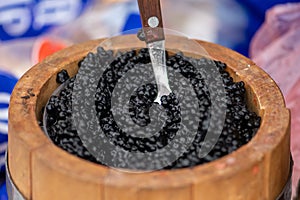 Salmon roe or sturgeon black caviar served in a wooden barrel