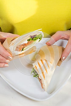 Salmon roll kebab in jands of woman