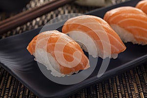Salmon or sake nigiri sushi served on a black serving plate photo