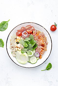 Salmon salad for ketogenic diet with shrimp, avocado, spinach, cucumber, tomato, cashew nuts, sesame. Low-carbohydrate breakfast