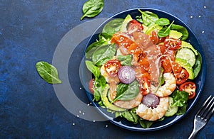 Salmon salad for ketogenic diet with shrimp, avocado, spinach, cucumber, tomato, cashew nuts, sesame. Low-carbohydrate lunch rich