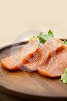 Salmon sashimi in chopsticks, Raw fresh salmon sliced with wasabi and sauce. Japanese food style