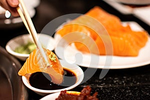 Salmon sashimi slice with shoyu sauce and wasabi. A famous Japanese food style