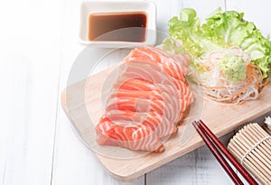 salmon sashimi on wood block and white wood background, Japaness food.