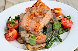 Salmon served with mushrooms asparagus cherry tomatoes