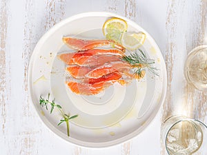 Salmon. Smoked salmon slices on white plate with wine.