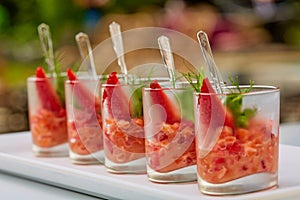 Salmon snack or tartar with strawberries in glass. Shalow dof photo