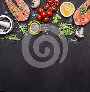 Salmon steak, butter, salt and pepper, lemon and cherry tomatoes on wooden rustic background top view border ,place for text