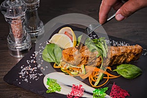 Salmon steak with lemon greens and sauce on stone with salt