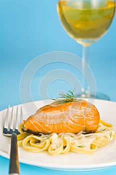 Salmon steak on pasta, decorated with dill