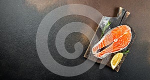 Salmon steak raw fish prepared for cooking fresh rosemary, spices, sea salt on a dark background. Long banner format
