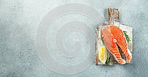 Salmon steak raw fish prepared for cooking fresh rosemary, spices, sea salt on a light background. Long banner format. top view