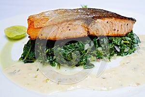 Salmon steak on spinach, selective focus