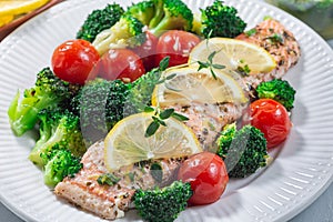 Salmon steak with vegetables, baked salmon fillet with broccoli and tomato, horizontal, closeup