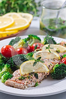 Salmon steak with vegetables, baked salmon fillet with broccoli and tomato on plate, vertical