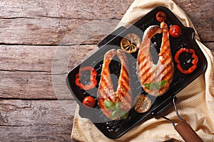 Salmon steak with vegetables on a grill pan. horizontal top view