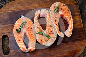 Salmon steaks on ice on wooden table. Fish food concept