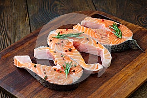 Salmon steaks on ice on wooden table. Fish food concept