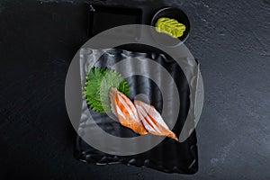 Salmon sushi on a black plate