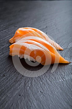 Salmon sushi on a black plate