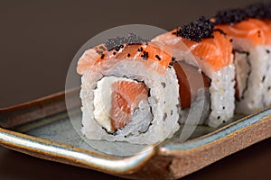 Salmon sushi roll aligned on plate