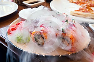 Salmon sushi rolls with dry ice smoke, Japanese food