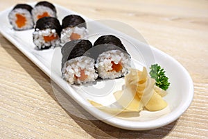 Salmon Sushi rolls with seaweed or Maki Sushi on white ceramic plate