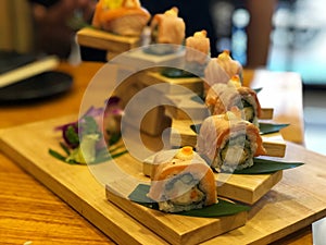 Salmon sushi rolls set on the wooden plate. Fresh and delicious sushi Japanese food.