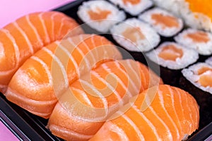 Salmon sushi and sashimi nigiri and maki roll closeup. Delicious japanese food with fresh fish, restaurant delivery set