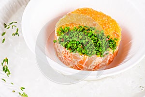 Salmon tartare with pike caviar on white plate