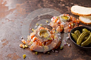 Salmon tartare with yolk, pickled cucumber and fresh onions