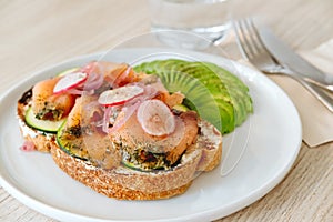 Salmon toast with avocado and vegs in the modern cafe