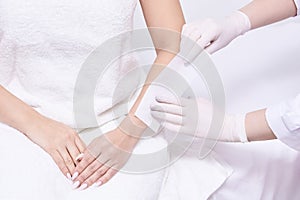 Salon forearm shugaring procedure. Doctor arm cosmetology salon
