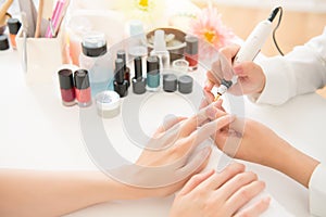 Salon manicurist using electric nail drill