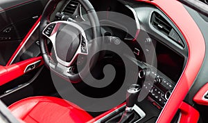 Salon sports car. Steering wheel, dashboard. Leather, red stitching.