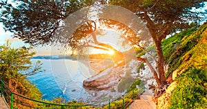 Salou. Spain. Sunny seascape. Green trees and grass on Costa Dorada coast line.