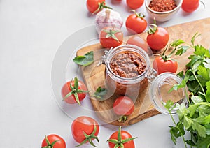 Salsa or adjika sauce is a traditional Mexican or Caucasus sauce with tomatoes and hot peppers on a light background with fresh