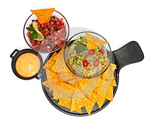 Salsa and guacamole Mexican dip sauce served in glass bowl with nachos or tortilla chips isolated on white background