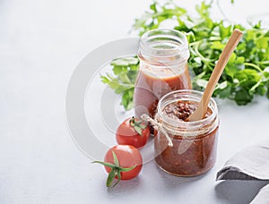 Salsa sauce is a traditional Mexican sauce with tomatoes and hot peppers on a light background with fresh herbs