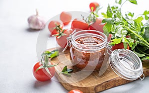 Salsa sauce is a traditional Mexican sauce with tomatoes and hot peppers on a light background with fresh herbs close up
