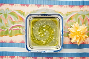 salsa verde in a square dish, blue tablecloth