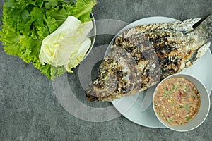 Salt crusted grilled fish with spicy dip and fresh vegetables